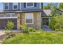Attractive home featuring a stone facade, well-kept lawn, and a welcoming entrance at 9545 Grand Cypress Cv, Lone Tree, CO 80124