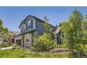 Inviting two-story home with mature trees, stone details, and lush greenery at 9545 Grand Cypress Cv, Lone Tree, CO 80124