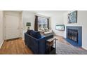Cozy living room features a blue fireplace, TV, couches, and hardwood floors at 12125 Bannock St # C, Westminster, CO 80234