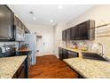 Modern kitchen with stainless steel appliances, granite countertops, and sleek black cabinetry at 12744 Leyden St # F, Thornton, CO 80602