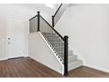 Staircase features black metal railings, carpeted treads, and wood-look flooring at the base at 13750 Emerald Lake St, Parker, CO 80138