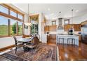 Bright dining area adjacent to the kitchen, featuring large windows with scenic views and stylish furnishings at 6194 Falcon Ridge Way, Morrison, CO 80465