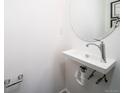 Modern powder room with a floating sink, brushed nickel fixtures, and clean white walls at 13588 E 103Rd Pl, Commerce City, CO 80022