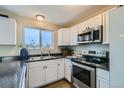 Modern kitchen features stainless steel appliances and white cabinetry at 11058 Grange Creek Dr, Thornton, CO 80233