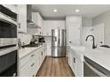Modern kitchen with white cabinets, stainless steel appliances and a large island at 7875 Yampa River Ave, Littleton, CO 80125