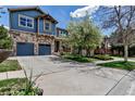 Charming exterior showcasing a blue-paneled and stone facade, two-car garage, welcoming porch, and neatly maintained lawn at 25245 E Park Crescent Dr, Aurora, CO 80016