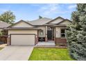Charming single-Gathering home showcasing a well-maintained lawn, two-car garage, and inviting front entrance at 10553 Stonemeadow Dr, Parker, CO 80134