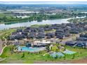 Aerial view of the community featuring houses, pool, tennis courts, landscaping and surrounding lakes at 12826 Lake Port St, Longmont, CO 80504