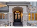 Elegant front entrance features a wrought iron double door, stone columns and custom lighting at 4505 W 100Th Ave, Westminster, CO 80031