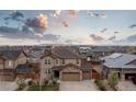 An aerial view of a neighborhood showcasing a brown home with an attached three-car garage at 25064 E Archer Pl, Aurora, CO 80018