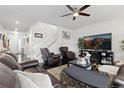 A cozy living room features a leather sofa, a ceiling fan, and a white staircase at 25064 E Archer Pl, Aurora, CO 80018