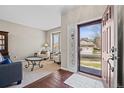 Inviting entryway with wood floors and an open floor plan leading into a carpeted living area at 6994 S Fultondale Cir, Aurora, CO 80016