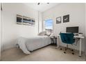 Cozy bedroom with a comfortable bed, a desk, a blue chair, and plenty of natural light from the window at 1950 N Logan St # 905, Denver, CO 80203