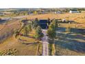 Aerial view of home on a large lot, featuring mature trees, a long driveway and fenced yard at 2312 Arabian Trl, Elizabeth, CO 80107