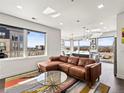 Bright, open living room with a comfortable leather sofa, modern decor, and scenic city views at 1898 S Bannock St # 404, Denver, CO 80223
