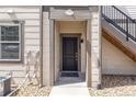Inviting front door with covered entrance, stairs, and neutral exterior paint scheme at 4605 Copeland Loop # 103, Highlands Ranch, CO 80126