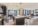 Open-concept kitchen with island, pendant lighting, and stainless steel appliances at 14315 Big Stone Dr, Parker, CO 80134