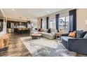 Spacious living room with large windows, hardwood floors, and modern furnishings at 14315 Big Stone Dr, Parker, CO 80134