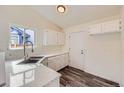 Updated kitchen features sleek countertops, stainless steel sink, white cabinets, and wood-look flooring at 9526 Pinebrook St, Highlands Ranch, CO 80130