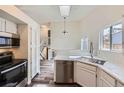 Modern kitchen with stainless steel appliances, white cabinets, quartz countertops, and stylish plank flooring at 9526 Pinebrook St, Highlands Ranch, CO 80130