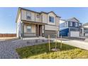 Well-maintained two-story home with neutral siding, a covered porch, and a two-car garage at 2231 Crosswind St, Fort Lupton, CO 80621