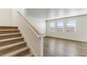 Bright living room with light-colored floors and lots of natural light from the many windows at 2231 Crosswind St, Fort Lupton, CO 80621