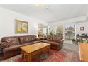 Living room with brown leather couches, a coffee table, and a view to a patio at 6405 S Dayton St # 105, Englewood, CO 80111