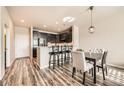 Charming kitchen/dining space with dark cabinets and a breakfast bar, and updated flooring at 1817 S Buchanan Cir, Aurora, CO 80018