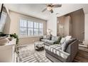 Cozy living room with large windows, a comfortable gray sectional, and stylish decor at 1817 S Buchanan Cir, Aurora, CO 80018