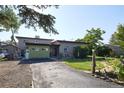 A spacious home with a long driveway, attached garage, and lush landscaping at 1075 S Ames St, Lakewood, CO 80226