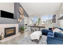 Bright living room with a fireplace, vaulted ceiling, and large windows offering natural light and a cozy atmosphere at 970 S Dawson Way # 15, Aurora, CO 80012