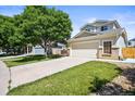 A beautifully landscaped home featuring a spacious driveway and a well-maintained lawn at 20455 E Grand Ln, Aurora, CO 80015