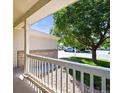 View from the covered porch of a home, with a cozy railing and well-kept landscaping at 20455 E Grand Ln, Aurora, CO 80015