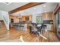 Open-concept kitchen and dining area features natural wood cabinets, a breakfast bar, and hardwood floors at 10756 Timothys Dr, Conifer, CO 80433