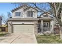 Charming two-story home boasts a well-manicured lawn, brick accents, and a cozy front porch to relax and enjoy the view at 10065 Cairns Ct, Highlands Ranch, CO 80130