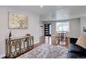 Cozy living room with a decorative console, plush rug, and view of the dining area at 2389 Nome St, Aurora, CO 80010