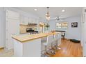 Spacious kitchen featuring a large center island with seating, white cabinetry, and modern appliances at 8390 E Davies Pl, Centennial, CO 80112