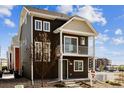 Two-story home featuring a balcony, brown siding, and a well-maintained front yard at 5383 Andes St, Denver, CO 80249