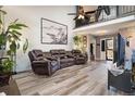 Spacious living room with a high ceiling, featuring a comfortable leather sofa set and stylish decor at 15393 E Louisiana Ave, Aurora, CO 80017