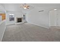 Bright, open living room with neutral paint, carpet, a ceiling fan and a fireplace at 381 Freestone St, Brighton, CO 80603