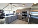 Open kitchen with stainless steel appliances, tile backsplash, island, and views to the living room at 8209 Balsam Way, Arvada, CO 80005