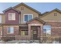 Tan and brick townhouse exterior with a small front yard and metal fence at 6448 Silver Mesa Dr # B, Highlands Ranch, CO 80130