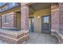 Townhouse entry with brick columns and a small patio at 6448 Silver Mesa Dr # B, Highlands Ranch, CO 80130