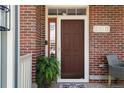Inviting front entry with a classic door, brick facade, and charming decor at 8318 Devinney Ct, Arvada, CO 80005