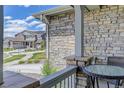 View from porch featuring stone detailing, outside seating, and a glimpse of the surrounding neighborhood at 22593 E Piccolo Way, Aurora, CO 80016