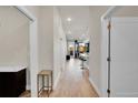 Hallway view to kitchen with island, pendant lights, and wood flooring at 6619 E Lowry Blvd # 112, Denver, CO 80230