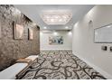 Modern hallway featuring artistic wall textures, contemporary lighting, and unique carpet design at 6619 E Lowry Blvd # 112, Denver, CO 80230