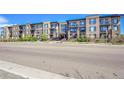 Multi-story condo building featuring brick facade, balconies, and well-manicured landscaping at 6619 E Lowry Blvd # 112, Denver, CO 80230