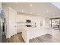 Modern kitchen with white cabinets, stainless steel appliances, island, and access to the deck at 2956 S Quaker St, Morrison, CO 80465
