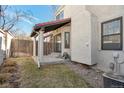 Private backyard area featuring a covered patio, green grass, and a partial fence surround at 1530 S Quebec Way # 34, Denver, CO 80231